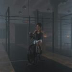 Trening tlenowy i beztlenowy: różnice, które warto znać przed planowaniem Kobieta trenuje na rowerze stacjonarnym w przyciemnionej siłowni