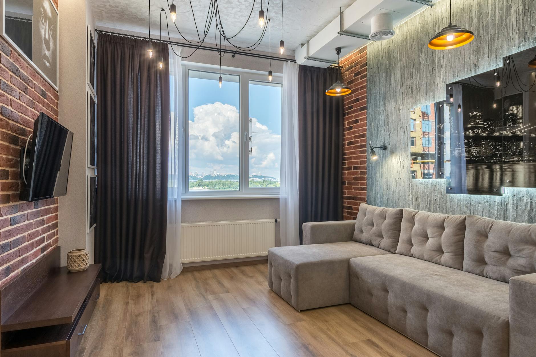 Nowoczesny salon w stylu loft z dużym oknem i industrialnymi dodatkami