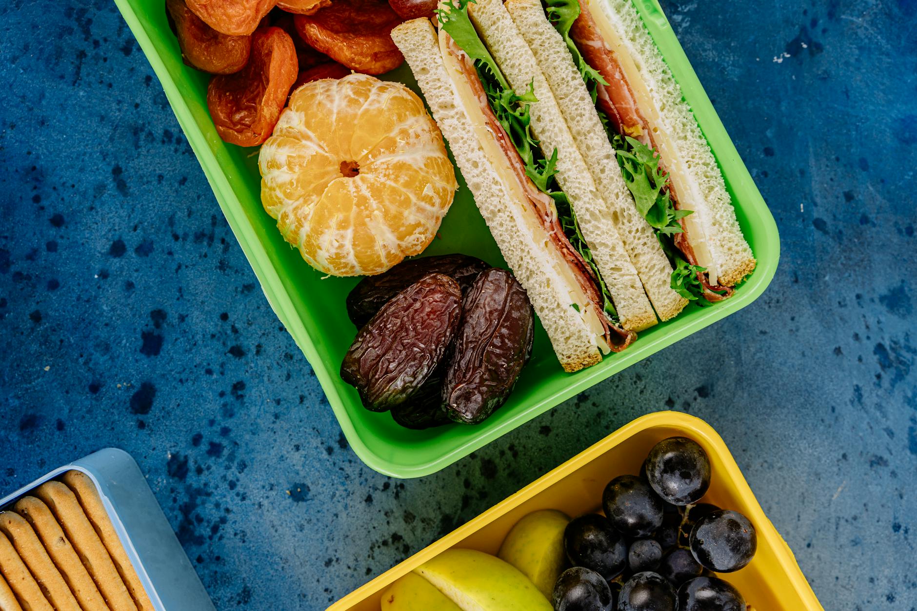 Kolorowe lunchboxy z kanapkami, owocami i zdrowymi przekąskami