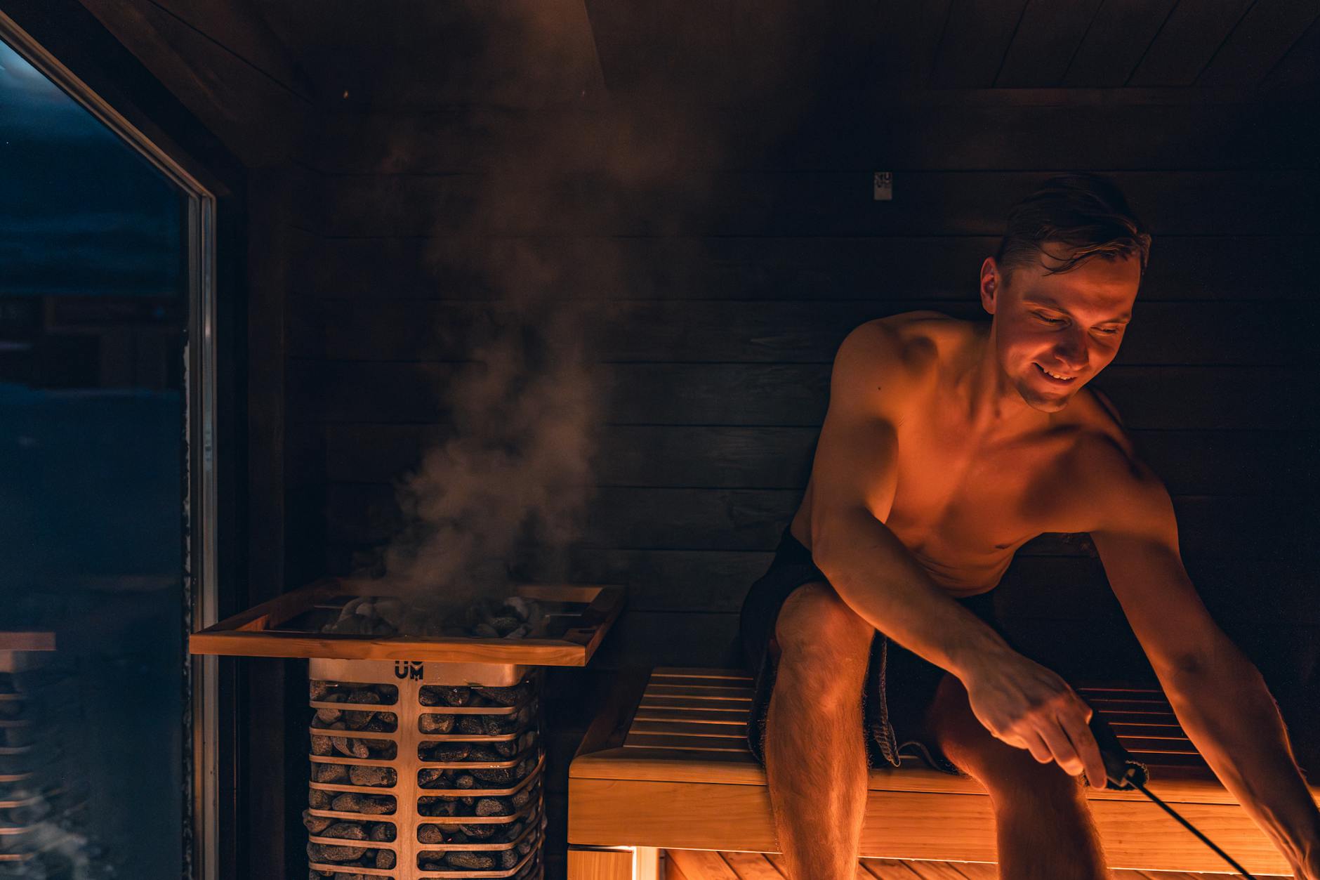 Mężczyzna relaksuje się w drewnianej saunie po treningu