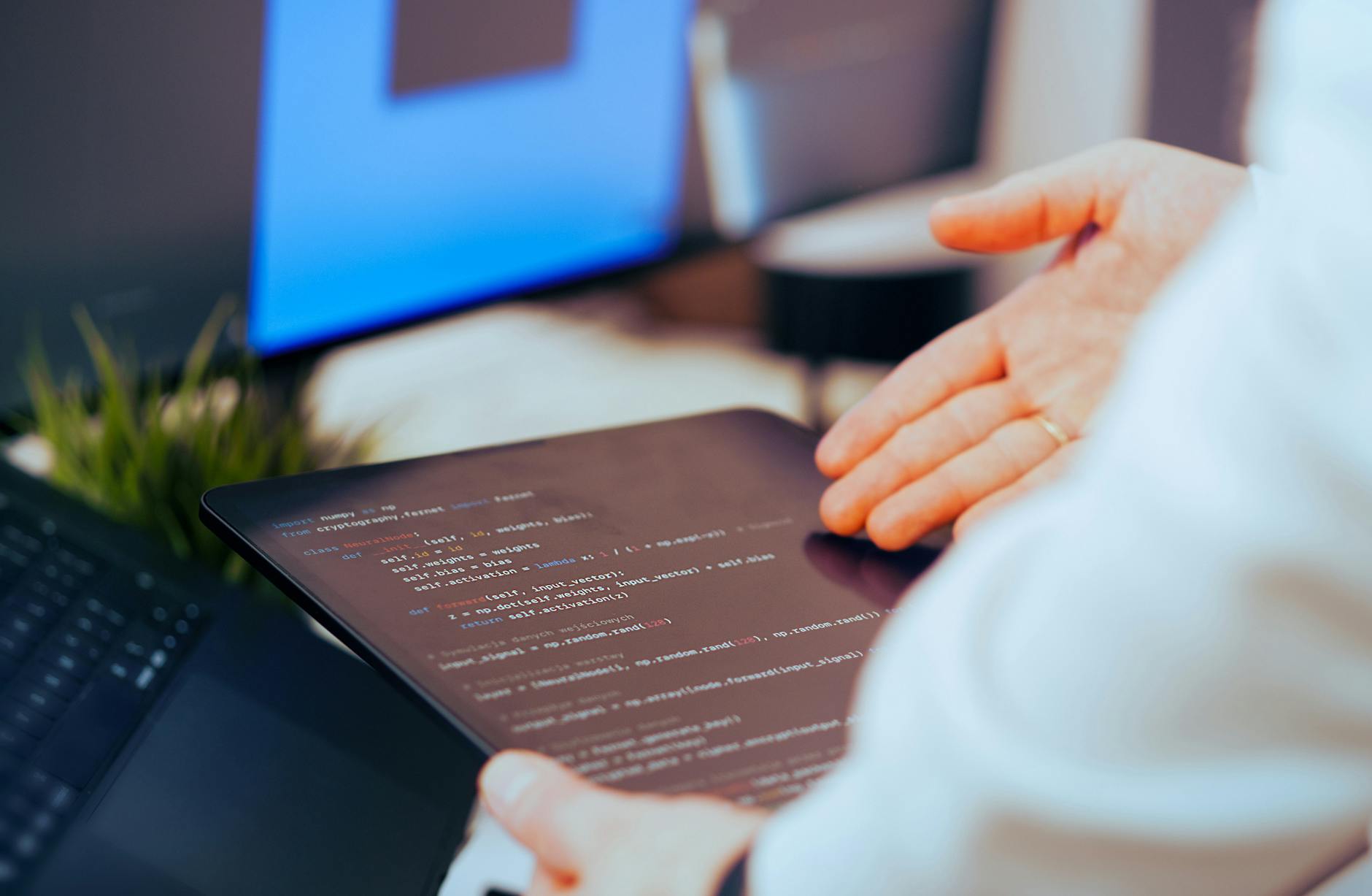 Jak bezpiecznie korzystać z generatywnej AI w pracy z dokumentami i danymi firmowymi Programista analizuje kod na tablecie w nowoczesnym biurze