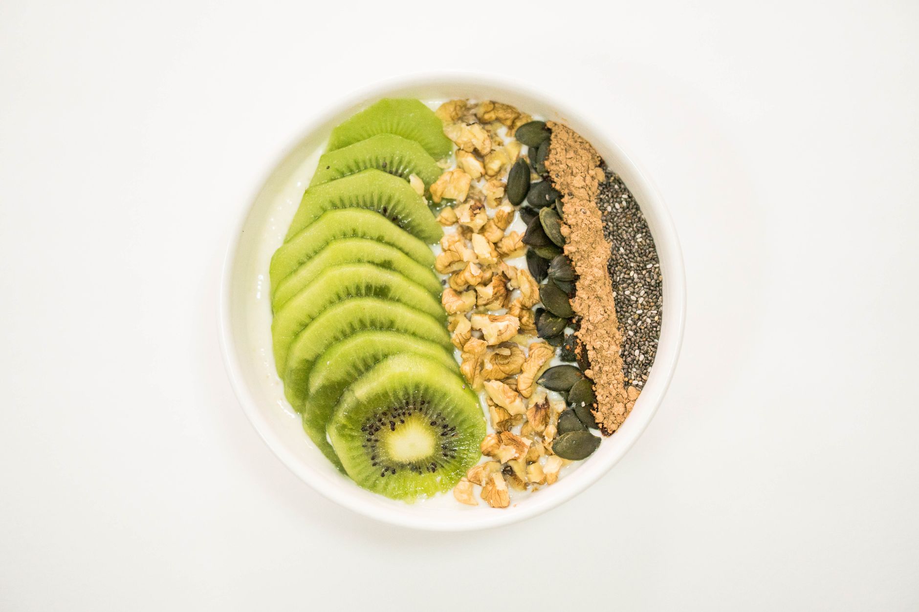 Miska smoothie z jogurtem, kiwi, orzechami i nasionami jako zdrowe śniadanie Miska smoothie z jogurtem, kiwi, orzechami i nasionami jako zdrowe śniadanie