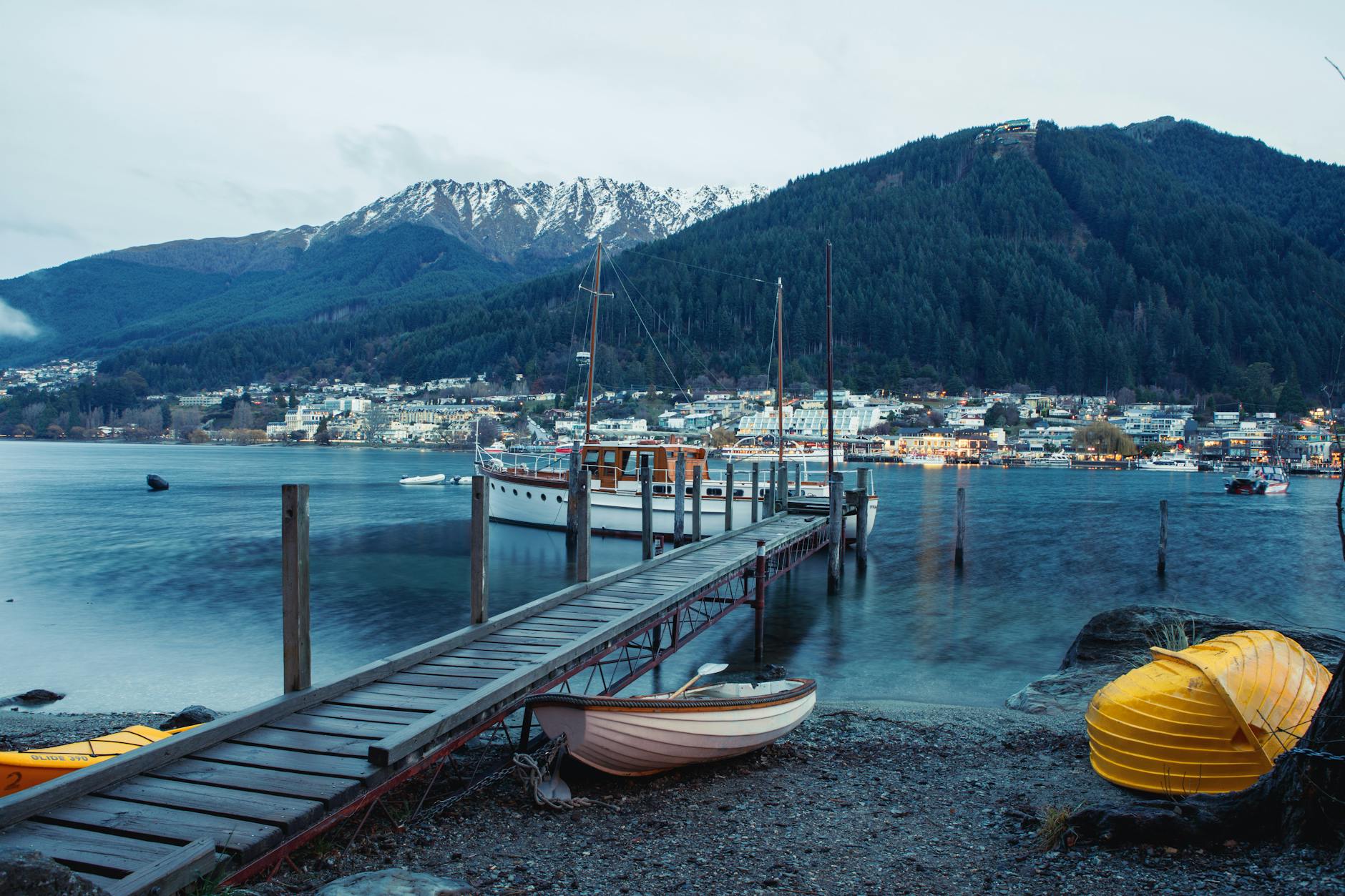 Przystań w Queenstown z zacumowanymi łodziami i górskim tłem